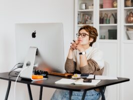 focused female employee reading information on computer in office